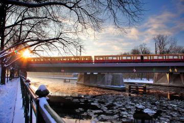 Sunrise in winter along the Spree with a class 481 S-Bahn on the light rail line