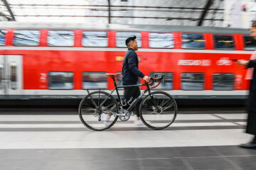 Ein Reisender schiebt ein Fahrrad über den Bahnsteig im Berliner Hbf