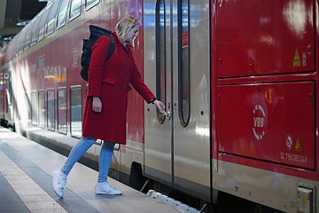 Reisende drückt die Türöffnertaste an einem Regionalzug