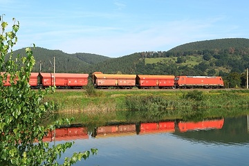 Unterwegs im Tal der Saale - bei Etzelbach in Thüringen spiegelt sich ein Güterzug der DB Cargo mit Ellok Baureihe 185 im Wasser der Saale.