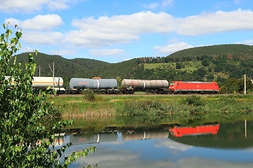 Unterwegs im Tal der Saale - bei Etzelbach in Thüringen spiegelt sich im Wasser der Saale ein Kesselwagenganzzug mit einer DB Cargo Ellok der Baureihe 185.