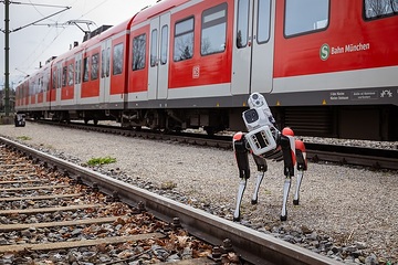 DB testet Roboterhund Spot bei der S-Bahn München. Der Roboterhund patrouilliert auf seinen vier Beinen eigenständig über Abstellanlagen und erkennt KI-gestützt dabei unbefugte Personen oder andere Unregelmäßigkeiten.